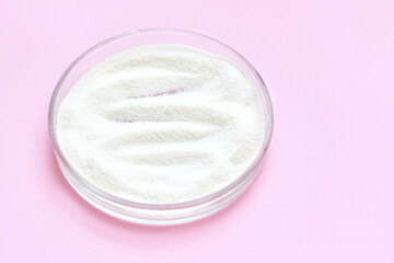 Collagen white powder. Pastel color background. Health product. Woman cosmetics concept. Sport supplement. Skincare cosmetics. Pink monochrome. Cream smear.