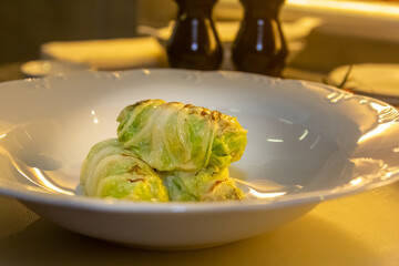 Stuffed cabbage rolls with meat on a plate with sour cream