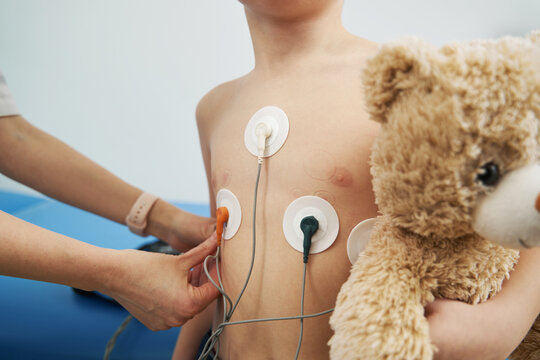 Pediatrician checking child heart rhythm with ECG holter monitor