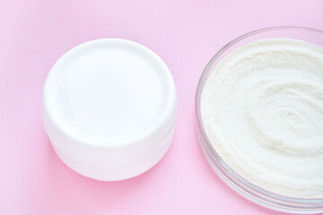 Collagen white powder. Pastel color background. Health product. Woman cosmetics concept. Sport supplement. Skincare cosmetics. Pink monochrome. Cream smear. Jar