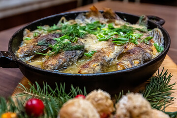Fish baked in sour cream in a frying pan