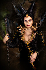 MALEFIC COSPLAY. PORTRAIT, DARK CHARACTER WITH SHARP HORNS AND STRONG WINGS. EVIL FAIRY IN BLACK DRESS. VERTICAL PHOTOGRAPHY.