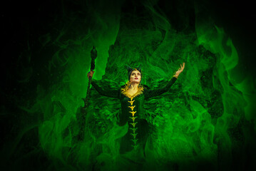 MALEFIC COSPLAY. PORTRAIT, DARK CHARACTER WITH SHARP HORNS AND STRONG WINGS. EVIL FAIRY IN BLACK DRESS. GREEN COLOR.