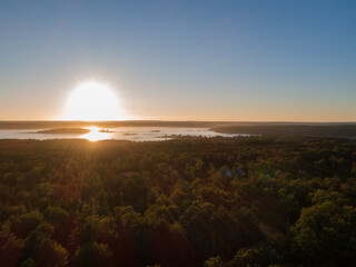 Burning sun over lake with tree canopies