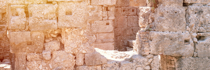 ruined construction of the old stone building. explore the ancient excavations of the ruins of the ancient Lycian city of Phaselis in Turkey in summer nature in the mountains outdoor. banner. flare