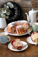 Raspberry roll wreath. Brioche. Side view, wooden background, coffee, powdered sugar, yeast buns. 