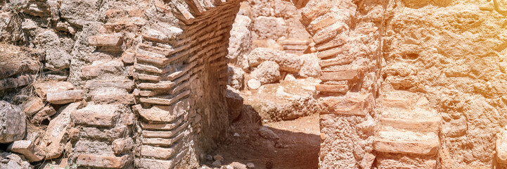 ruined construction of the old doorway building. explore the ancient excavations of the ruins of the ancient Lycian city of Phaselis in Turkey in summer nature in the mountains outdoor. banner. flare