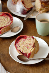 Raspberry roll wreath. Brioche. Side view, wooden background, coffee, powdered sugar, yeast buns. 