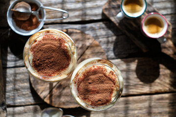 Portioned tiramisu in a glass. Wooden background, top view