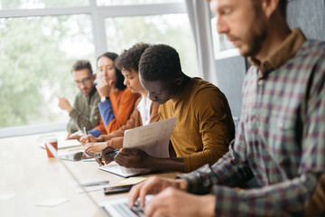 variety of employees sitting at a desk in a coworking center.