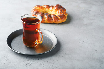 Turkish black tea. Glass cup of turkish black tea and crispy Turkish traditional bagel on gray...