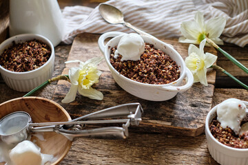 Crumble with apple and chocolate. Narcissus, ice cream, wood background, side view, vensa.
