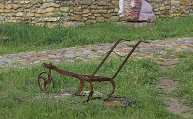 Vintage agricultural equipment for manual tillage. Vintage decoration in a Bessarabian village. A metal tool used in the early 20th century. Odessa Oblast, Ukraine.