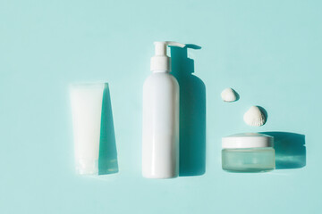 Eco-friendly cosmetics for face and body skin care. White tube, bottle and jar of cream on a blue background. Hard Shadows.