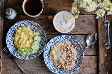 Breakfast. Oatmeal with nuts, scrambled eggs and cucumbers