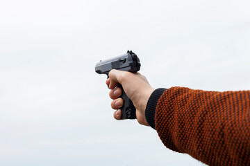 man holding a gun in his hands on a light background