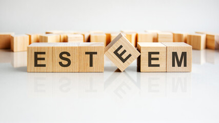 ESTEEM text on a wooden blocks, gray background.