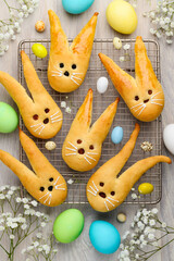 Easter bunny buns from yeast dough on a wire rack. Multicolored eggs. Traditional Easter dessert,...