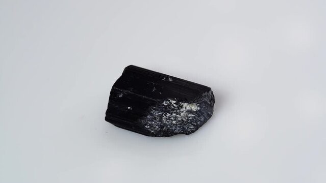 black tourmaline scherl rough specimen on the white background turning table