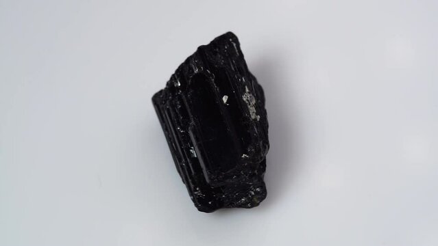 black tourmaline scherl rough specimen on the white background turning table