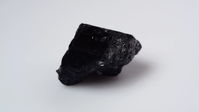 black tourmaline scherl rough specimen on the white background turning table