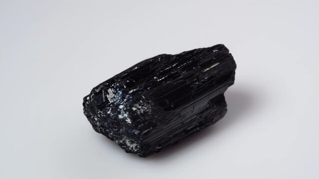 black tourmaline scherl rough specimen on the white background turning table