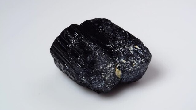 black tourmaline scherl rough specimen on the white background turning table
