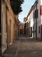 Ferrara, Italy. Downtown, medieval cobbled street with archway.