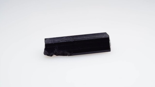black tourmaline scherl rough specimen on the white background turning table