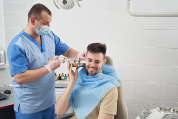 Obraz premium Cheerful young man during procedures at otorhinolaryngologist