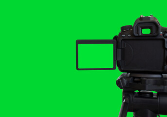 Dslr camera with empty screen on the tripod, isolated on green background. Green screen camera.