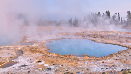 Thermal Pool in Yellowstone. Steam and crystal blue water