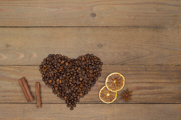 Coffee beans heart shape, cinnamon sticks and dry lemon slices on an old wooden background. Coffee design concept.
