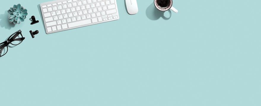 Computer keyboard with a cup of coffee and eyeglasses - flat lay