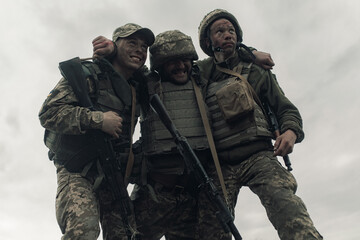 Two Ukrainian soldiers drag wounded warrior after battle against russian enemy.