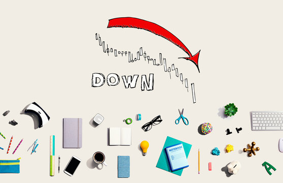Market down trend chart with collection of electronic gadgets and office supplies