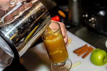 The bartender at the bar prepares orange grog - obrazy, fototapety, plakaty
