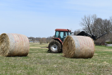 Obraz premium Hay Bales by a Tractor