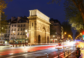 Paris, the porte Saint-Martin, beautiful ancient gate near the Grands Boulevards at rainy night.