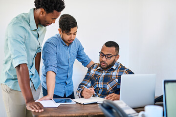 Hard work turns a startup into a success. Shot of a team of young entrepreneurs having a discussion in a modern office.