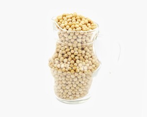 Close-up of soybean seeds in a clear glass jar isolated on white background