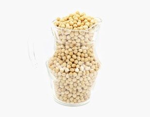 Close-up of soybean seeds in a clear glass jar isolated on white background