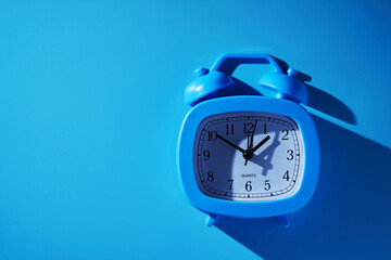 blue alrm clock against blue background