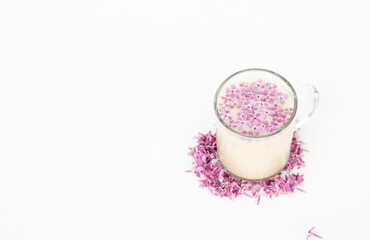 Cup of hot morning coffee and lilac petals on a white background. 