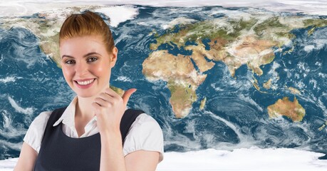 Portrait of caucasian woman showing thumbs up against world map in background