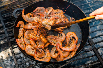 crispy fresh shrimp cooked on a frying pan in the wild. Rest in nature with fresh food
