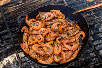 crispy fresh shrimp cooked on a frying pan in the wild. Rest in nature with fresh food
