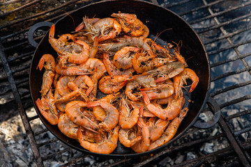 crispy fresh shrimp cooked on a frying pan in the wild. Rest in nature with fresh food
