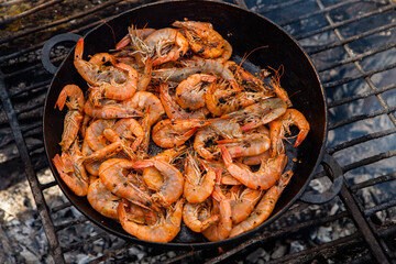 crispy fresh shrimp cooked on a frying pan in the wild. Rest in nature with fresh food
