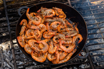 crispy fresh shrimp cooked on a frying pan in the wild. Rest in nature with fresh food
